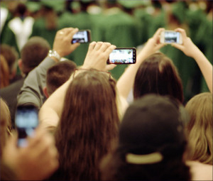 people in a crowd recording with their phones up