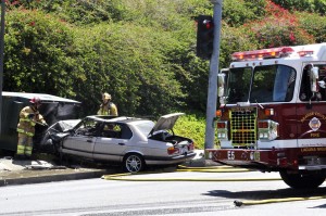 a car crash with fire fighters at the scene.